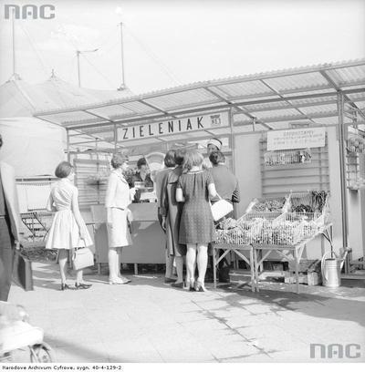 Klienci w kolejce przy stoisku z warzywami i owocami.1968 r.