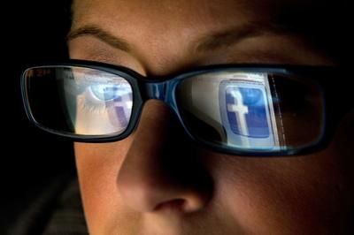 Użytkowniczka Facebooka śledzi portal (fot. Bloomberg)